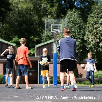 Kinder spielen Basketball